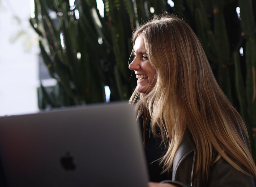 Recap Media team member laughing while working on a laptop