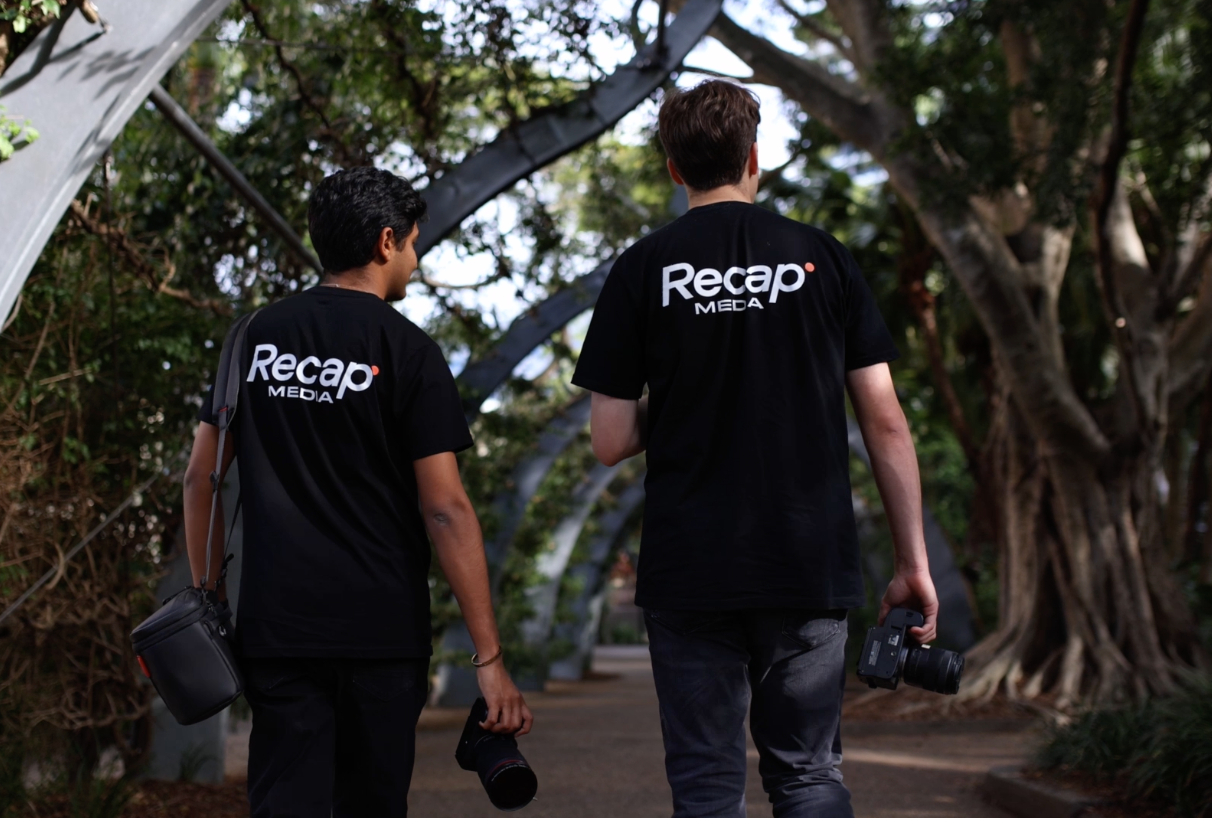 Two Recap Media videographers walking with camera gear on a shoot